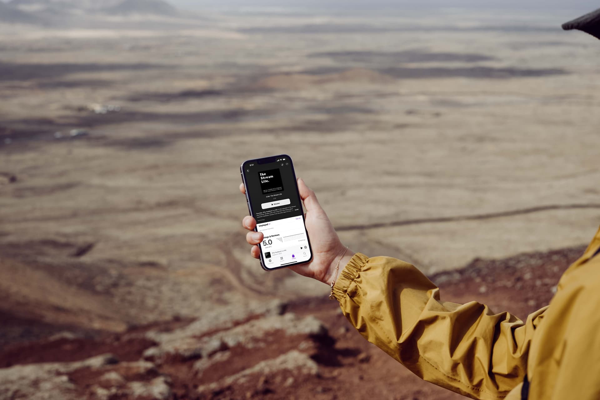 mockuuups-iphone-13-pro-mockup-held-by-a-user-over-a-large-field