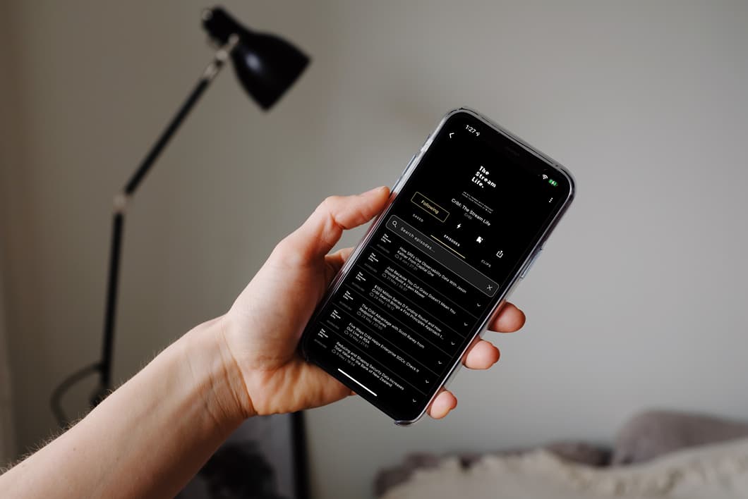 mockuuups-iphone-12-pro-mockup-held-by-user-with-a-reading-lamp-in-the-background