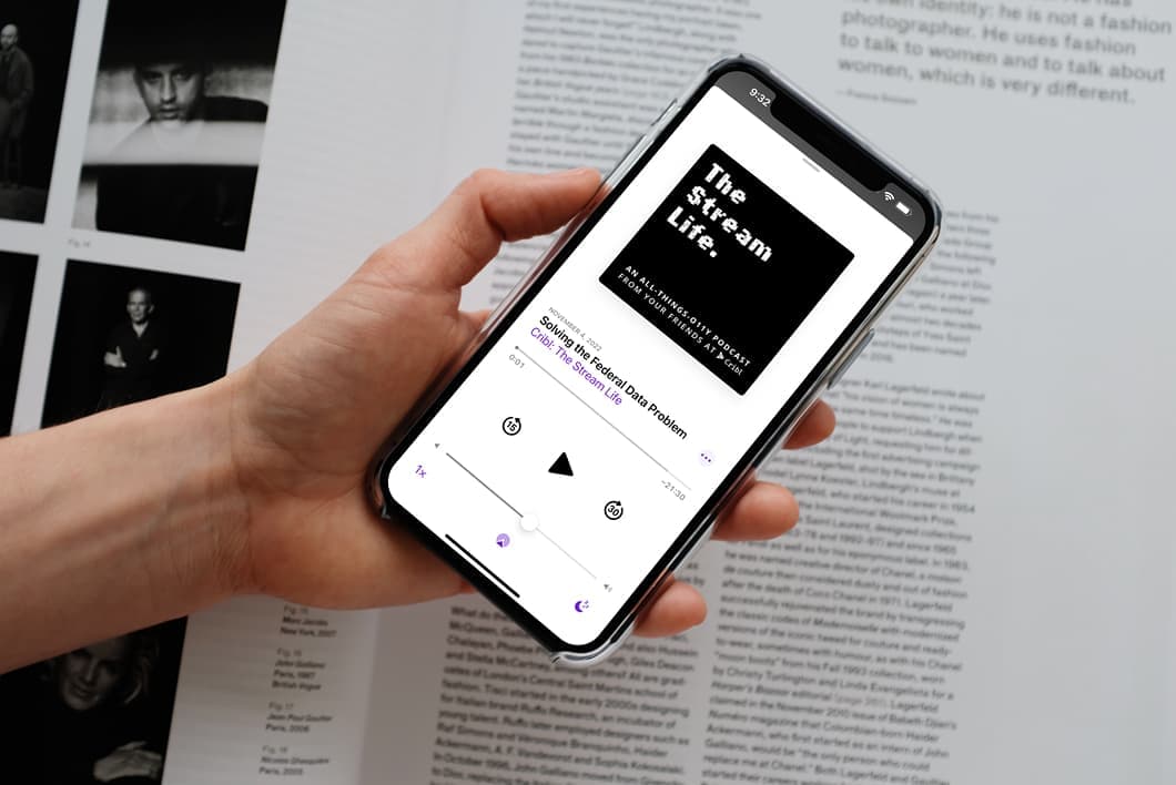 mockuuups-iphone-12-pro-mockup-held-by-user-over-an-open-magazine