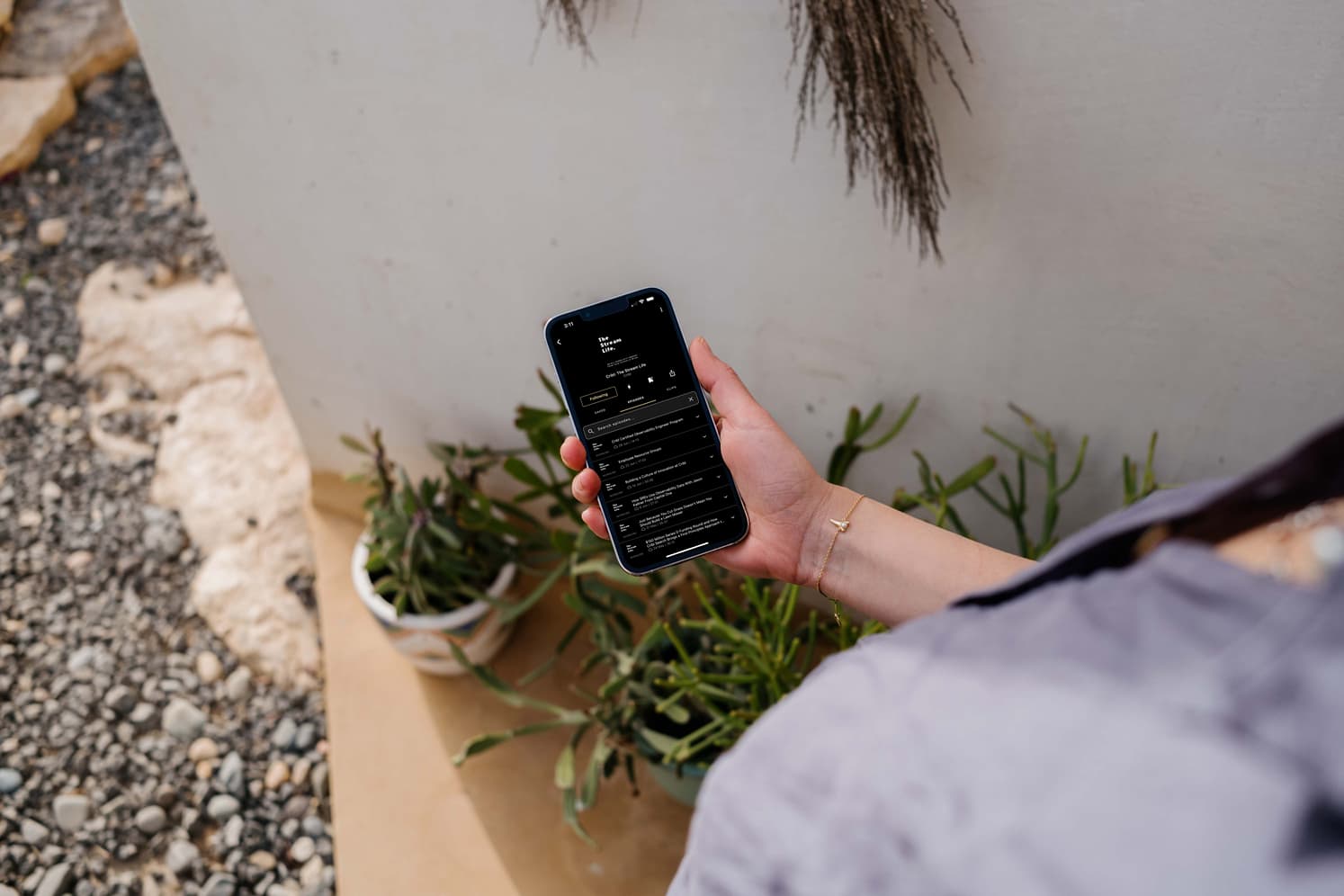 mockuuups-iphone-13-pro-mockup-held-by-a-user-outdoors